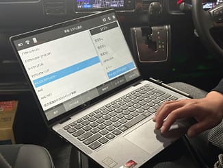 スキャンツールは診断だけじゃない!<br>現場で役立つ“作業サポート機能”の活用法 1 整備士が車内でスキャンツールを使って診断作業を行っている様子