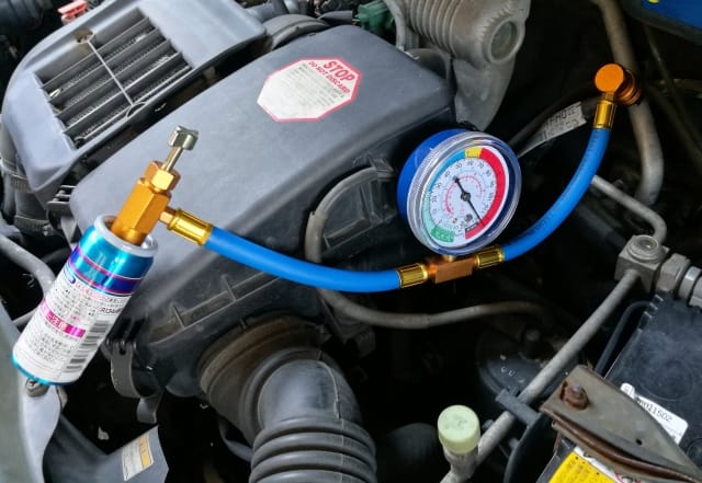 「エアコンガスが変わるってよ!」<br>~HFC-134aからR-1234yfへの整備マニュアル~ 3 自動車のエアコンガスを注入している整備士の作業風景(HFC-134aからR-1234yfへの交換)