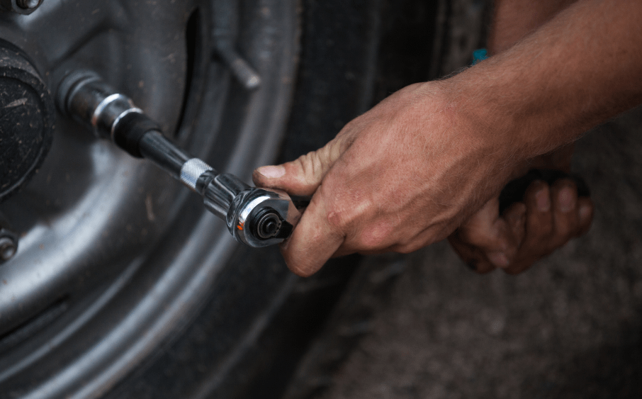 元工場長、こめかみピキッと沸点低めの日々を笑いで乗り切る整備士時代 2 ホイールの手締めを新人整備士に作業指導する元工場長のイメージ