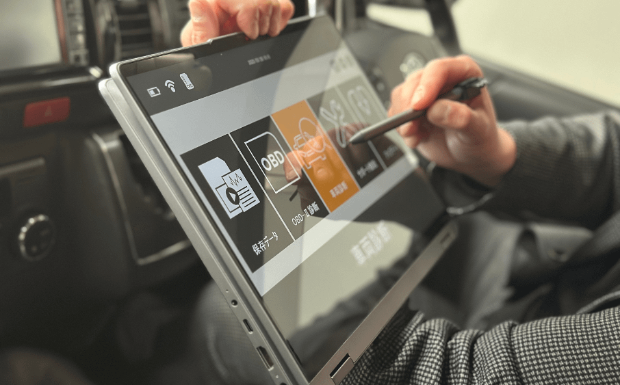 「ヒーター効かない!」その“ぬるさ”整備士は見逃さない 3 スキャンツールを使ってヒーターの動作を点検している整備士の作業風景